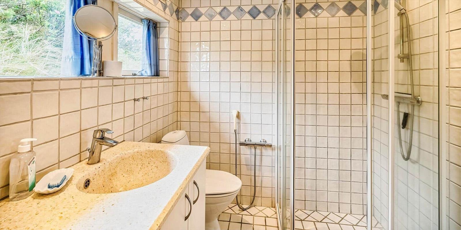 Schlafzimmer mit Bett unter schräger Decke und halbrundem Fenster.