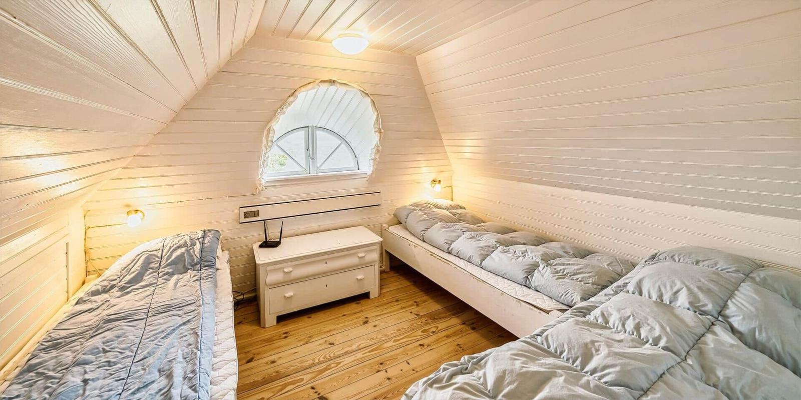 Holzgetäfeltes Treppenhaus mit blauem Sitzkissen und Blick in Schlafzimmer