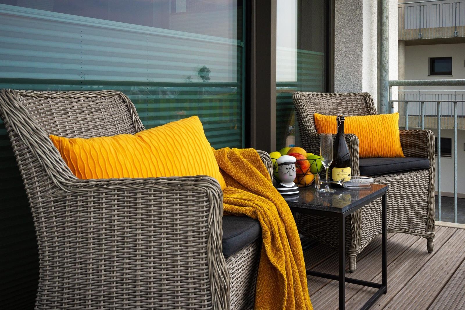 Schlafzimmer mit Bett und Wohnbereich mit Sofa und Terrassentür.