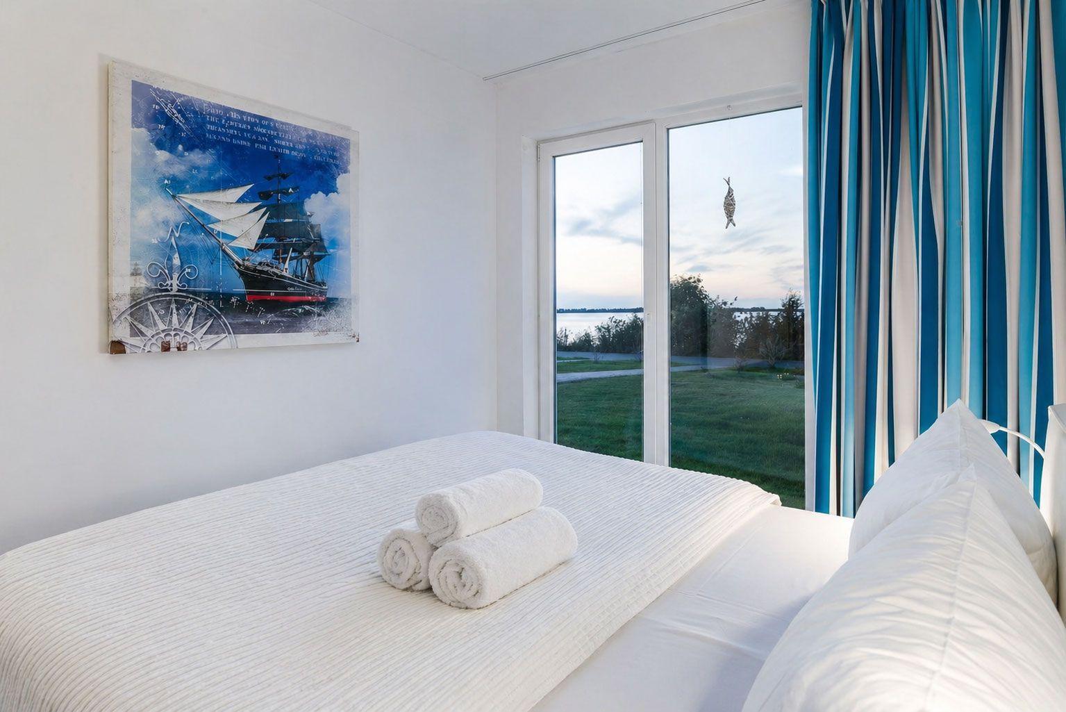 Aerielansicht einer schmalen Landzunge mit Leuchtturm und klarem Meer.