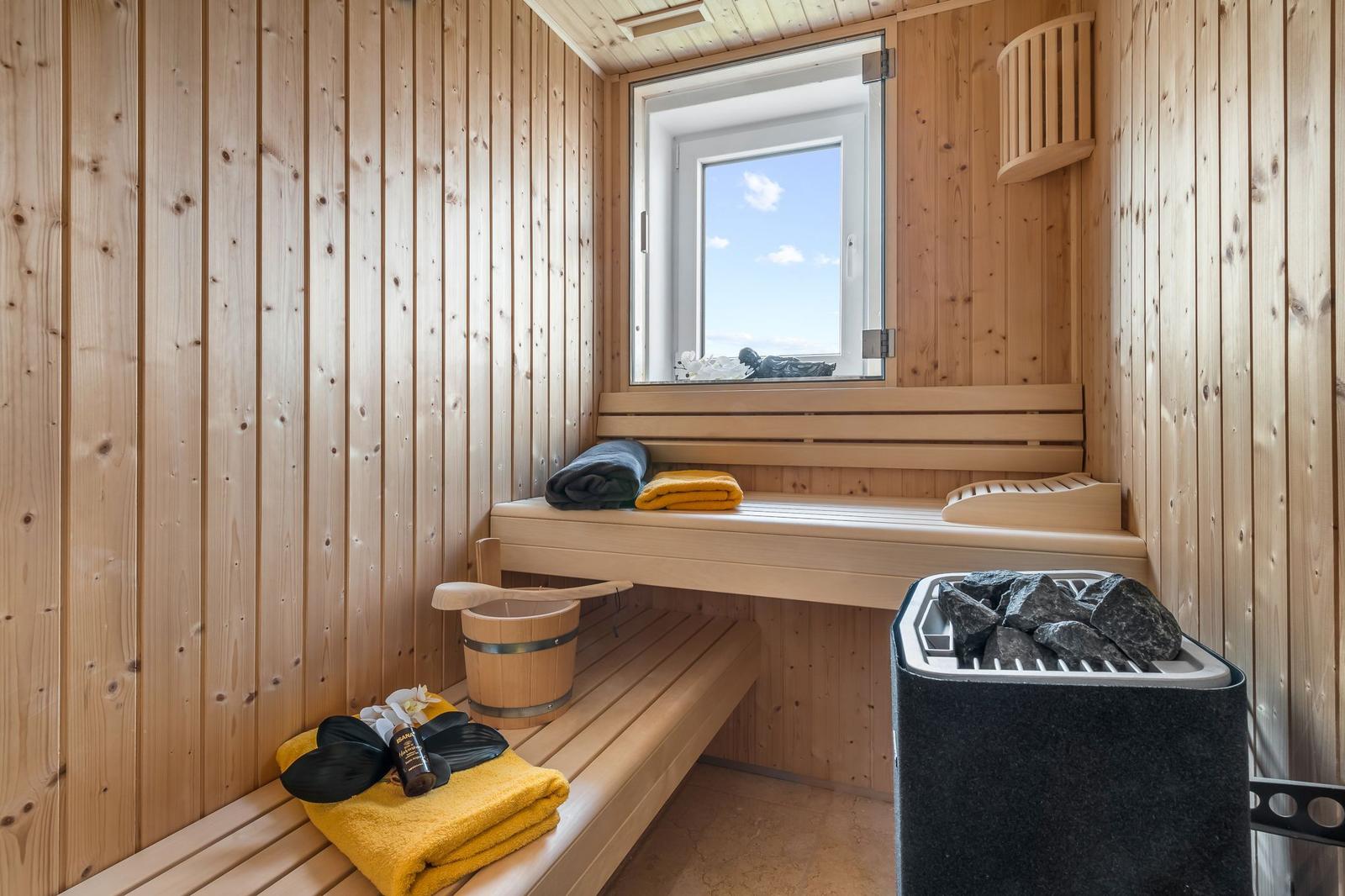 Wohnung mit Essbereich, roten Sesseln und floralen Sofas. Große Fenster mit Blick auf Balkon.