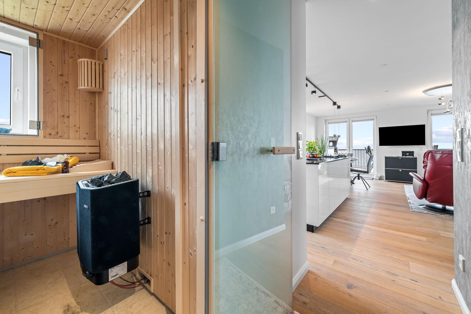 Wohnzimmer mit roten Sesseln, floralen Sofa und Holzboden.