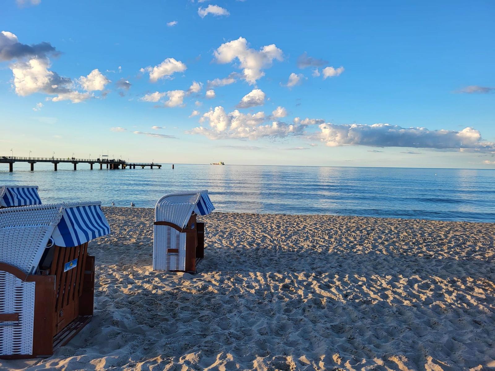 Strand mit Liegestühlen, Promenade und Steg zur See