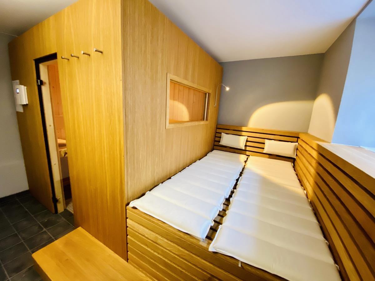 Bad mit Dusche, Holzbank und gemustertem Boden