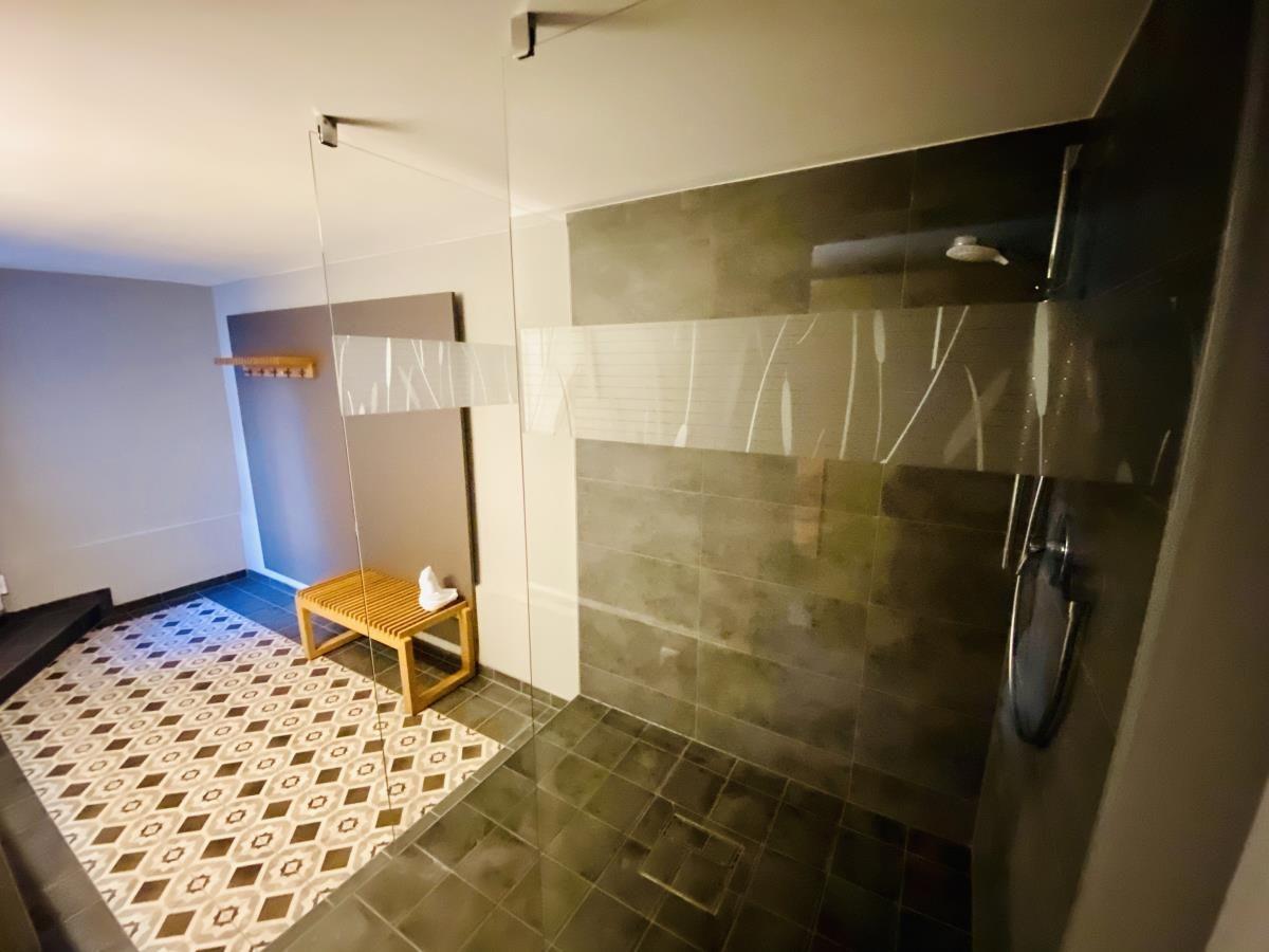 Waschmaschine mit Korb und Putzmittel in einem Raum mit Fliesenboden