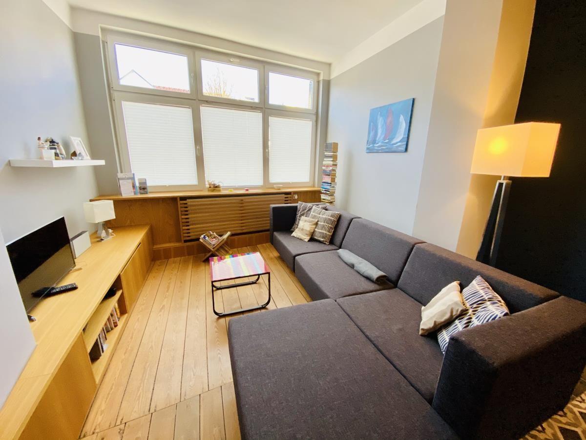 Schlafzimmer mit Holzbett, weißen Bettwäsche und Holzboden.