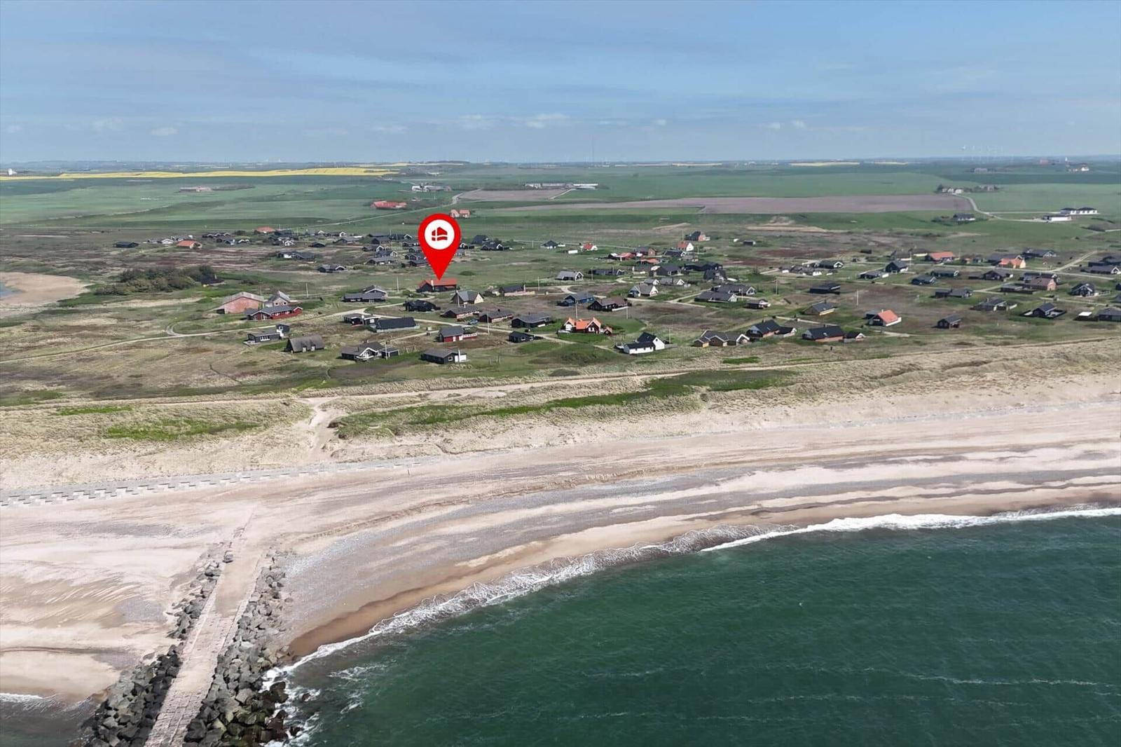 Haus mit rotem Dach in ländlicher Umgebung nahe Wasser