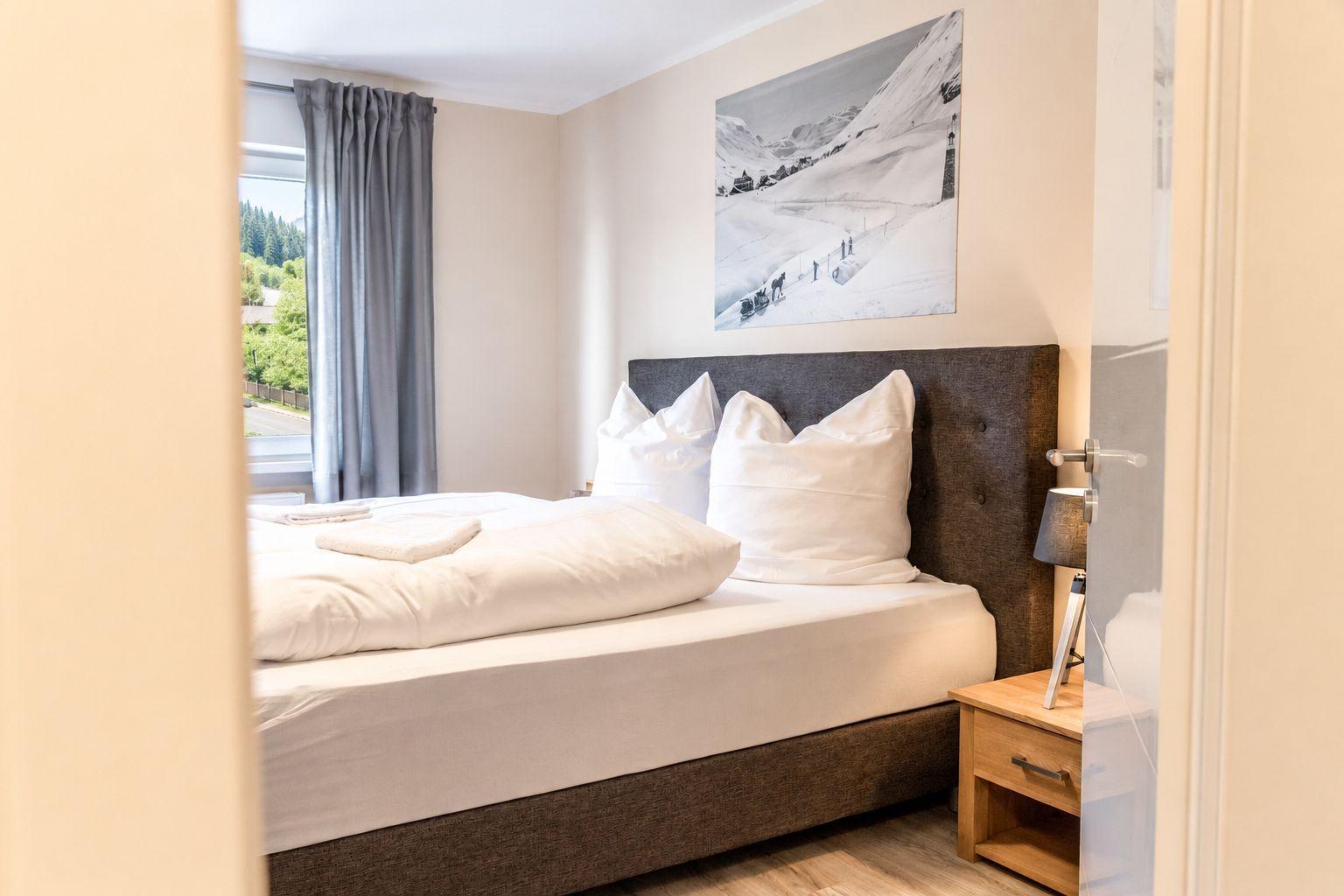 Ein modern eingerichtetes Apartment mit Schlafzimmer, Wohnbereich, Küche und Bad.