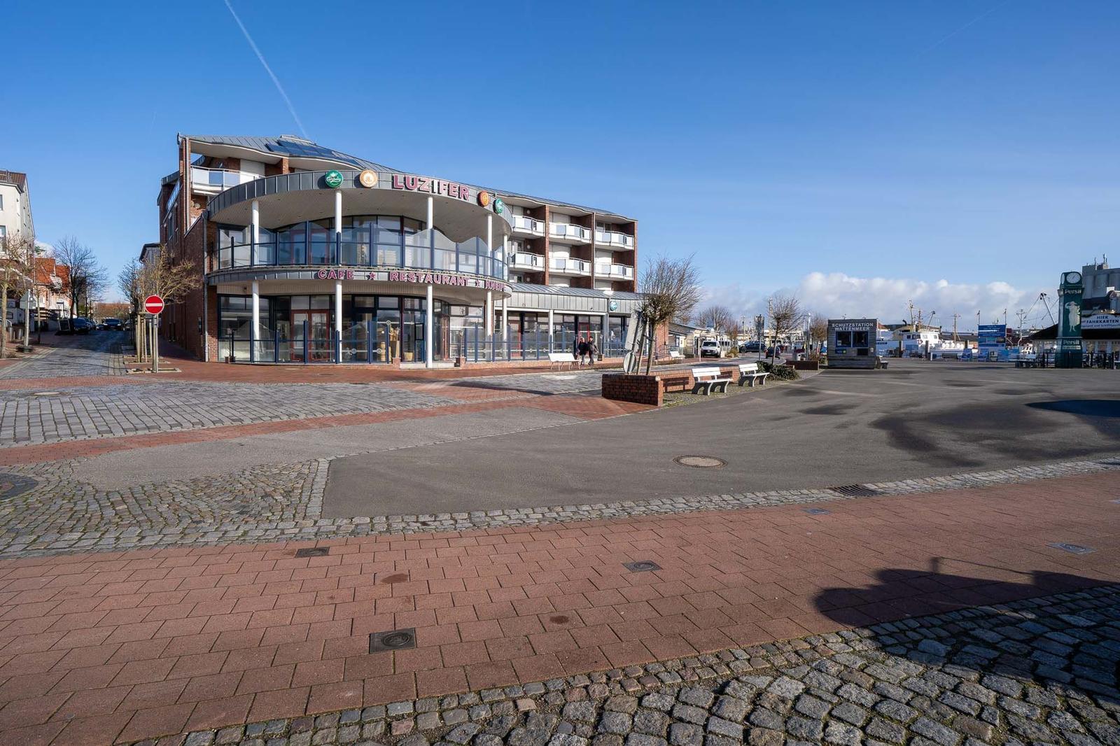 Hafen mit Leuchtturm, Booten und Parkplatz. Blick auf das Meer.