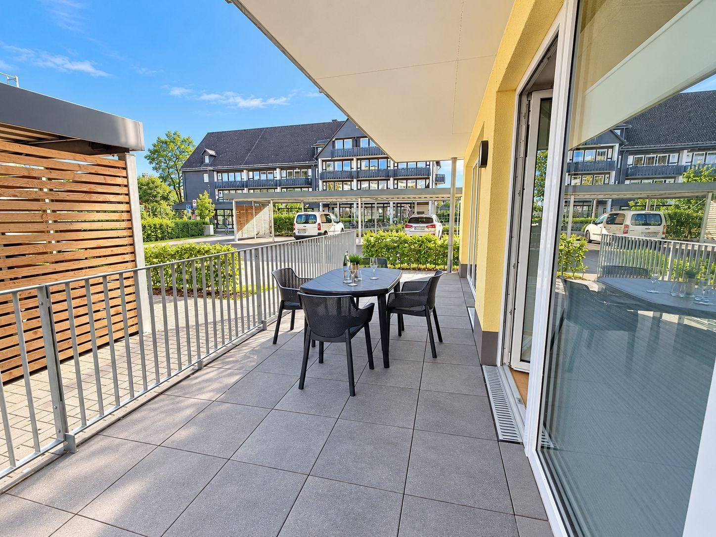This apartment has an open kitchen, a living room with a sofa, a bedroom, and a bathroom.