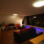 Wohnzimmer mit verdeckter LED RGB Lichtleiste im Einbauschrank für eine indirekte Beleuchtung. Die Farben können Sie mittels Fernbedienung selber bestimmen