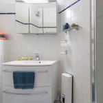 Badezimmer mit Toilette, Waschbecken und Spiegelschrank
