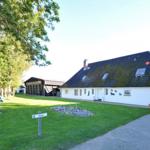 Wohnhaus mit Garten, Picknicktisch und Spielplatz. Weißes Gebäude mit dunklem Dach.