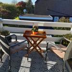 Terrasse mit Tisch und zwei Stühlen, Bezug auf Garten und Haus.
