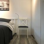Schlafzimmer mit Bett, Stuhl und Wandbild