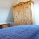 Schlafzimmer mit Holzschrank, Bett und Nachttisch