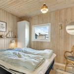 Schlafzimmer mit Holzwand, Bett, Stuhl und Fenster