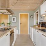 Moderne Küche mit Holzboden, weißen Schränken und Holzoberflächen.