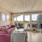 Wohnzimmer mit rosa Sofa, Fernseher und Blick auf die Terrasse.