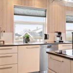 Küche mit Holzwänden, Arbeitsplatte und Fensterblick.