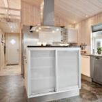 Küche mit Holzwand, Edelstahlgeräten und zentraler Arbeitsinsel.