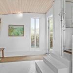 Eingangsbereich mit Holzbank, Wandbild und Treppe zur Küche.