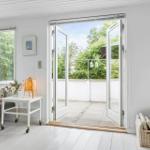 Wohnraum mit Blick auf Balkon, Fenster, Tisch und Stuhl.