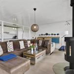 Wohnzimmer mit Sofa, Kamin und Küchenbereich im Hintergrund.