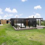 Moderne Ferienwohnung mit Terrasse und Garten. Glaswand umgibt die Außenterrasse.