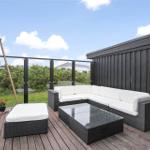 Terrasse mit weißer Außensitzgruppe und Glasgeländer