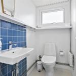 Badezimmer mit blauen Fliesen, Waschbecken und Toilette