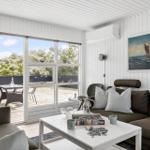 Wohnzimmer mit Sofa, Tisch und Blick auf Terrasse