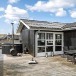 Terrasse mit Hot Tub, Sitzgruppe und Blick auf Dünen.