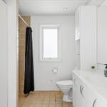 Badezimmer mit Dusche, Toilette und Waschbecken mit Spiegel