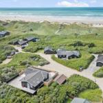 Meerfront-Villa mit Garten und Strandblick. Mehrere Häuser in Dünenlandschaft.