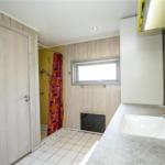 Badezimmer mit Dusche, Waschbecken und Fenster.