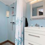Badezimmer mit Dusche, Waschbecken und Spiegel.