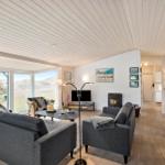 Living room with gray sofas, fireplace, and view of the landscape.