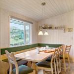 Dining room with wooden table, bench, and chairs. Window shows green landscape.