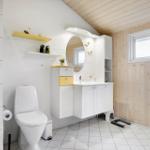 Bathroom with shower, toilet, and sink. Wooden wall, windows, and radiator.