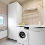 Washing machine and dishwasher in a room with wooden walls and window.