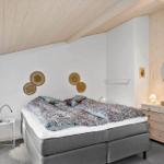 Bedroom with double bed, dresser, and wall decor.