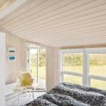 Bedroom with bed, white walls, and windows to the garden.