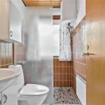 Badezimmer mit Toilette, Waschbecken und Dusche mit Duschvorhang.