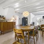 Esszimmer mit Holztisch, Stühlen und weißen Wänden.