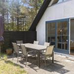 Terrasse mit Tisch und Stühlen neben einem Haus mit Glastüren.