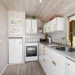 Küche mit weißen Schränken, Arbeitsplatte und Fenster