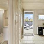 Helle Flure mit Holzwand und Terrasse mit Liegen.