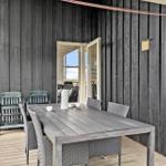 Terrasse mit Tisch und Stühlen, Tür führt ins Haus.