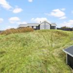 Moderne Villa auf grüner Anhöhe mit Blick auf den Himmel.